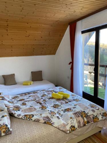 a bedroom with two beds and a large window at Vidikovac BIJELO POLJE in Bijelo Polje