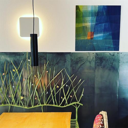 a table with a lamp and a painting on a wall at Albergo Wellness Da Febo in Tramonti di Sotto