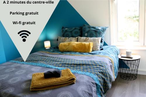 une chambre avec un lit avec un mur bleu dans l'établissement LD-Location Boulogne-sur-mer, à Boulogne-sur-Mer