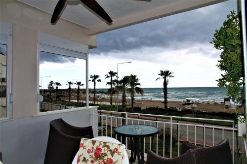 a balcony with a table and chairs and a view of the beach at Уютная квартира на берегу моря с частным бесплантным пляжем in Antalya