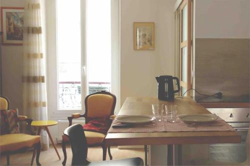 une salle à manger avec une table et des chaises en bois dans l'établissement 47m2 Calme au cœur de Parîs, à Paris