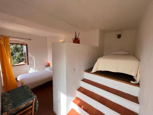 a bedroom with two beds and a staircase in it at Casa Musicale in Pigna