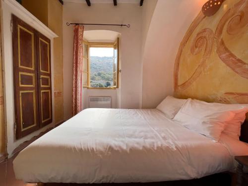 a bedroom with a large white bed with a window at Casa Musicale in Pigna