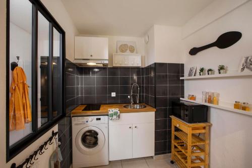 une cuisine avec une machine à laver et un évier dans l'établissement Studio Le Voltaire Sublime & Cosy proche Gare de Sète, à Sète