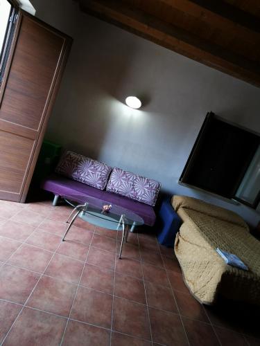 a living room with a purple couch and a flat screen tv at Villa Patrizia in Canicattì