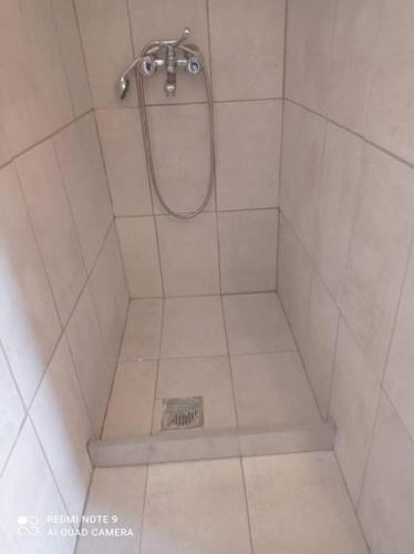 a bathroom with a shower with a drain in the floor at Ioli's Apartments in Archangelos
