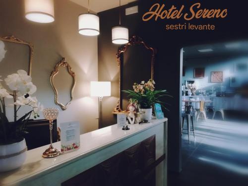 a dressing room with mirrors and flowers on a counter at Hotel Sereno in Sestri Levante