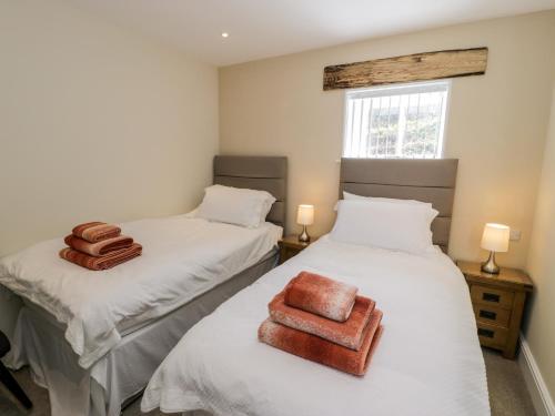 two twin beds in a room with towels on them at Bryn Goleu in Llandudno