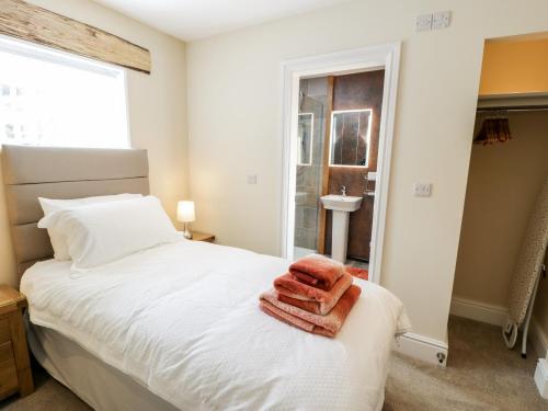 a bedroom with a white bed with towels on it at Bryn Goleu in Llandudno