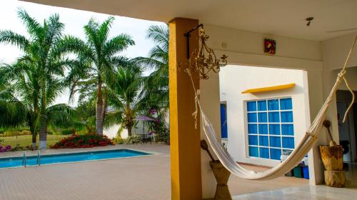 a house with a slide next to a swimming pool at Hotel - Granja de Animales San Basilio de Palenque in San Basilio del Palenque