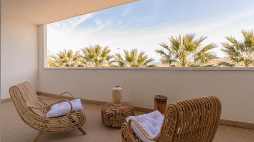 a balcony with chairs and a large window with palm trees at Residenza Excelsior in Vasto