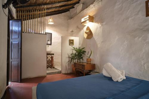 ein Schlafzimmer mit einem blauen Bett in einem Zimmer in der Unterkunft Hostal Colonial de Santander in Girón