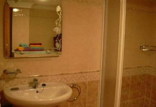 een badkamer met een wastafel en een spiegel bij Casa Galesa in Nerja