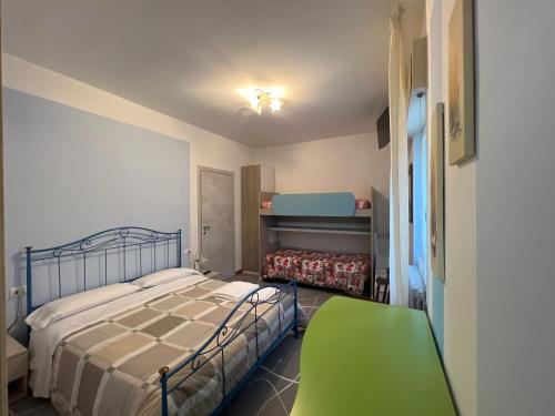 1 dormitorio con 1 cama y 1 silla verde en Macloud pub B&B, en Sarnico
