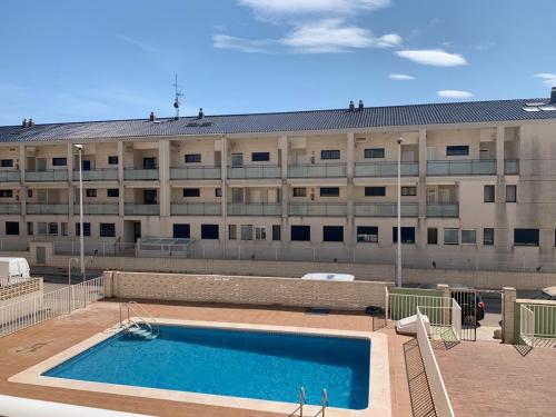 a building with a swimming pool in front of a building at Apto con piscina en la playa cerca de VLC con AC in Puzol