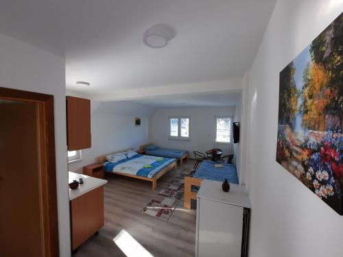 a room with two beds and a living room at Apartmani Vila na Drini in Foča