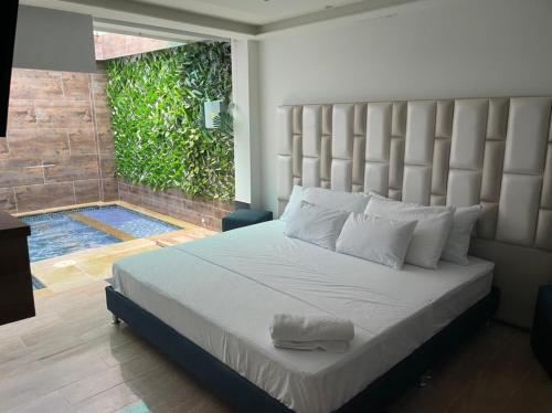 a bedroom with a large bed with a large headboard at Hotel River Suite in Leticia