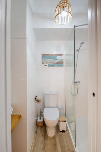 a bathroom with a toilet and a glass shower at Ocean House Alentejo in Porto Covo