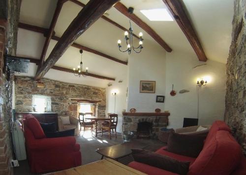 a living room with red couches and a fireplace at Wood House Cottage in Cockermouth