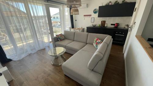 a living room with a couch and a table at Apartament Mechelinki, wysoki standard. in Pierwoszyno