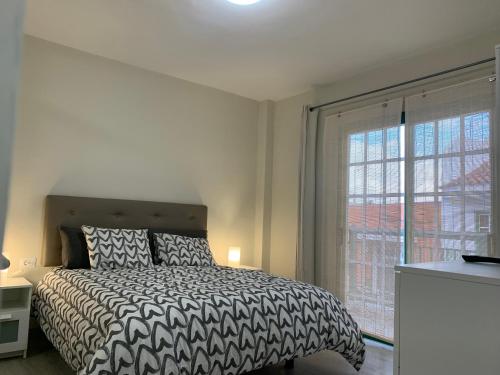 a bedroom with a bed and a large window at Casa Pablo IV AptºTranquilo, a cinco minutos del Puerto de la cruz in Los Realejos