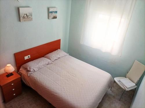 a small bedroom with a bed and a window at Casa Salamanca in Benidorm