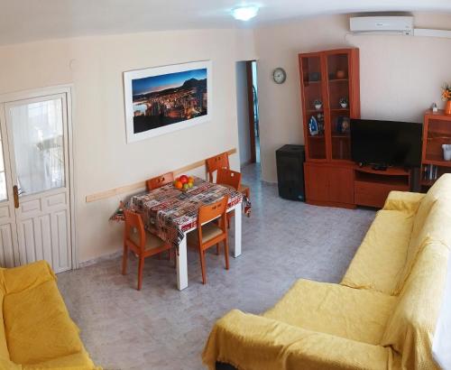 sala de estar con mesa, sillas y TV en Casa Salamanca, en Benidorm