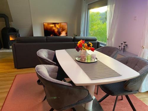 een woonkamer met een tafel met stoelen en een bank bij Haus Adler - Komplettes Ferienhaus am Badesee in Erzgrube