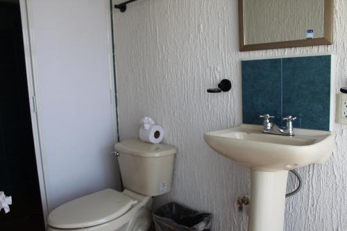 a bathroom with a toilet and a sink and a mirror at Posada Las Graditas in Sayulita
