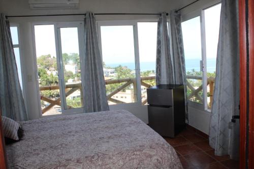 Un dormitorio con una cama y vista al mar. en Posada Las Graditas, en Sayulita