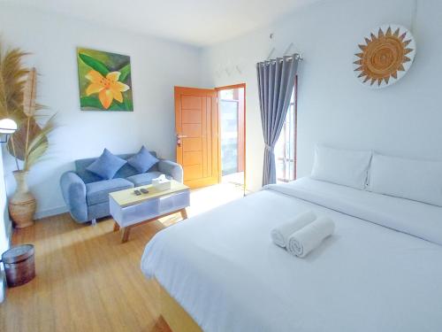 um quarto com uma cama branca e um sofá azul em Abams Gili Air em Gili Air