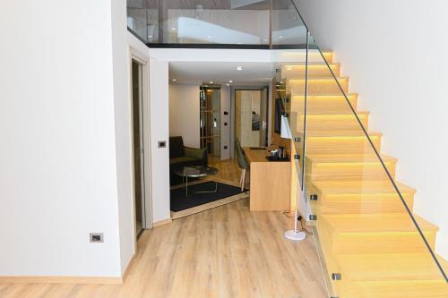 a staircase with a glass railing in a room at White Hill Hotel, SPA & Conferences in Durrës