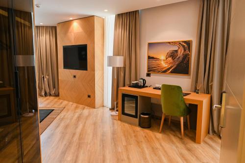 a hotel room with a desk and a green chair at White Hill Hotel, SPA & Conferences in Durrës