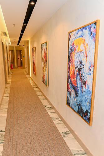 a hallway with paintings on the walls of a hospital at White Hill Hotel, SPA & Conferences in Durrës
