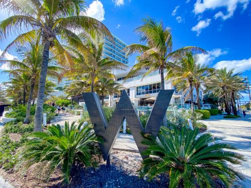 a sculpture in front of a hotel with palm trees at W Residences Fort Lauderdale Luxury Suites Across from Fort Lauderdale Beach in Fort Lauderdale