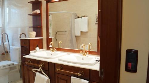 a bathroom with two sinks and a large mirror at Hotel Batán in Villalba