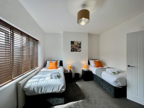 a bedroom with two beds and a window at Johnson House - Great for Contractors or Family Holidays in Cleethorpes
