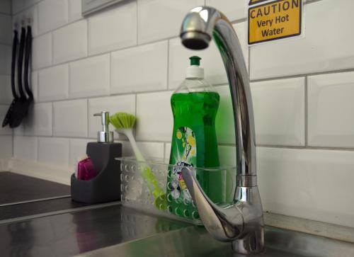 a kitchen sink with a green bottle of water at Nicola's Apartments in Kassiopi