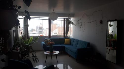 
a living room filled with furniture and a window at Moksha Yoga and Surf Penthouse in Huanchaco
