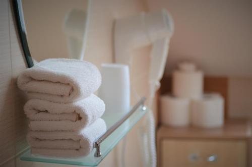 a stack of towels on a towel rack in a bathroom at Pension Vyhlídka in Český Krumlov