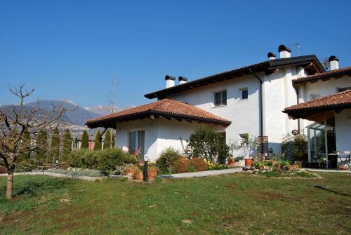 a large white house with a yard in front of it at casa Rosalba in Strigno