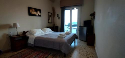 a bedroom with a bed and a large window at Captain's Rooms in Aegina Town