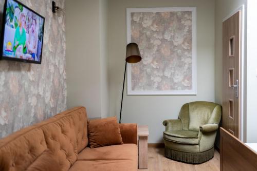 a living room with a couch and a chair at Pod Beczką in Augustów