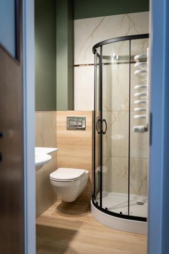 a bathroom with a toilet and a glass shower at Pod Beczką in Augustów