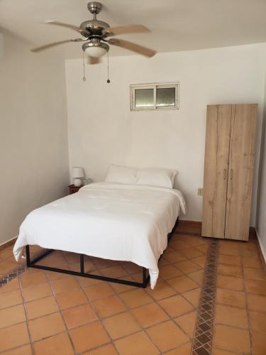 a bedroom with a bed and a ceiling fan at Paradise Found in La Ceiba