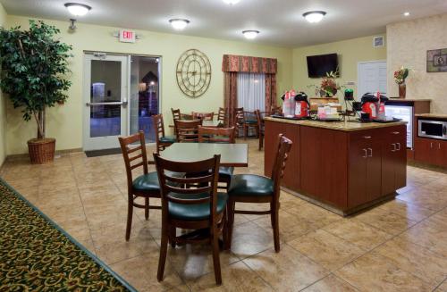 a kitchen and dining room with a table and chairs at GrandStay Residential Suites Hotel Faribault in Faribault
