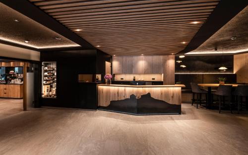 a lobby with a bar with a table and chairs at Hotel Klostersepp in Chiusa
