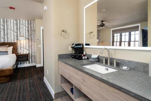 a bathroom with a sink and a large mirror at Ski Inn Taphouse Hotel in Sisters