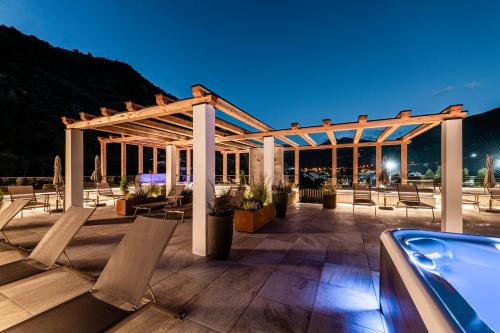 een terras met stoelen en 's nachts een zwembad bij Hotel Klostersepp - Neu in Chiusa