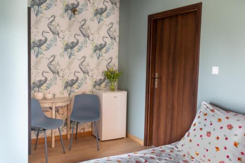 a bedroom with a bed and a table and chairs at Pod Beczką in Augustów